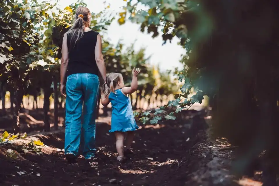 Mãe e filha caminhando pelo vinhedo da família